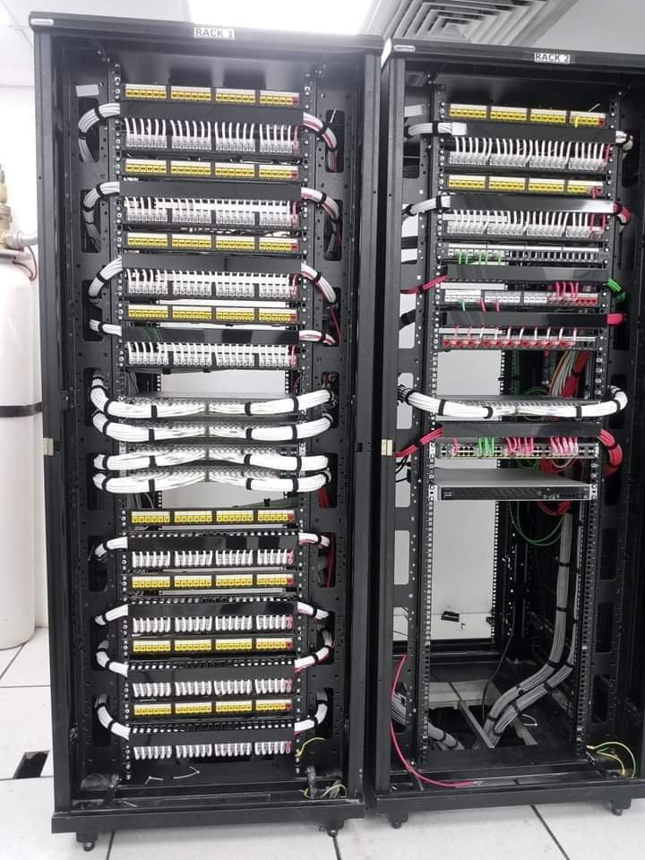 Two open network racks with organised white, yellow and red connections