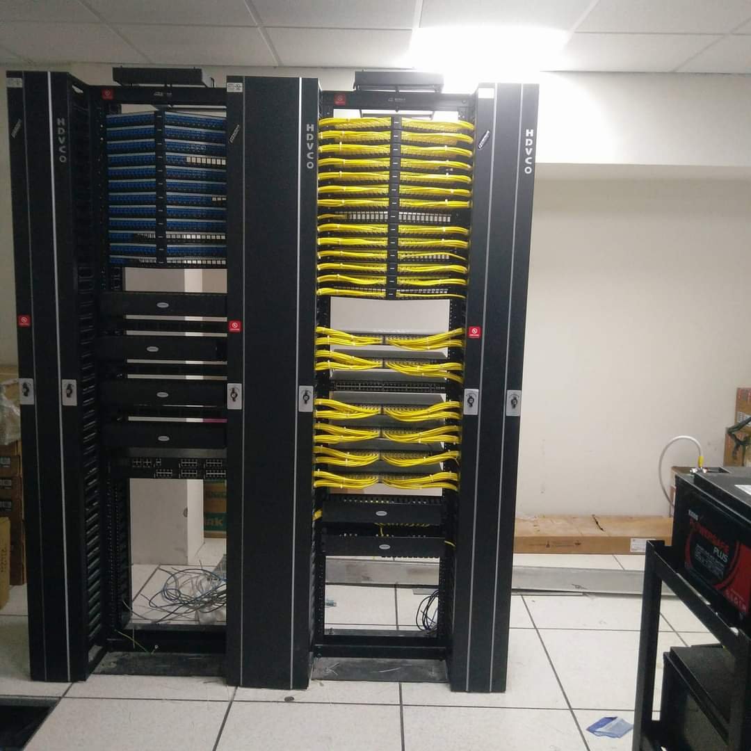 Two network racks with organised blue and yellow patch cables