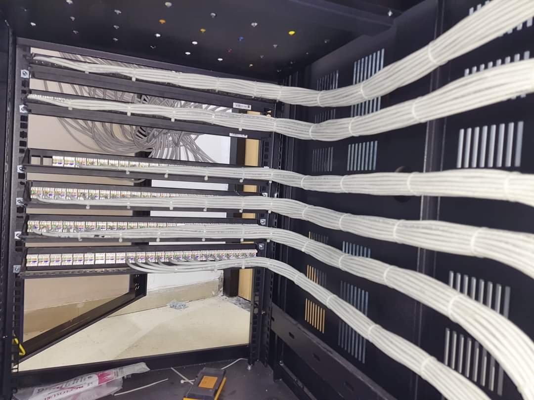 Neatly bundled white cabling at the rear of network patch panels
